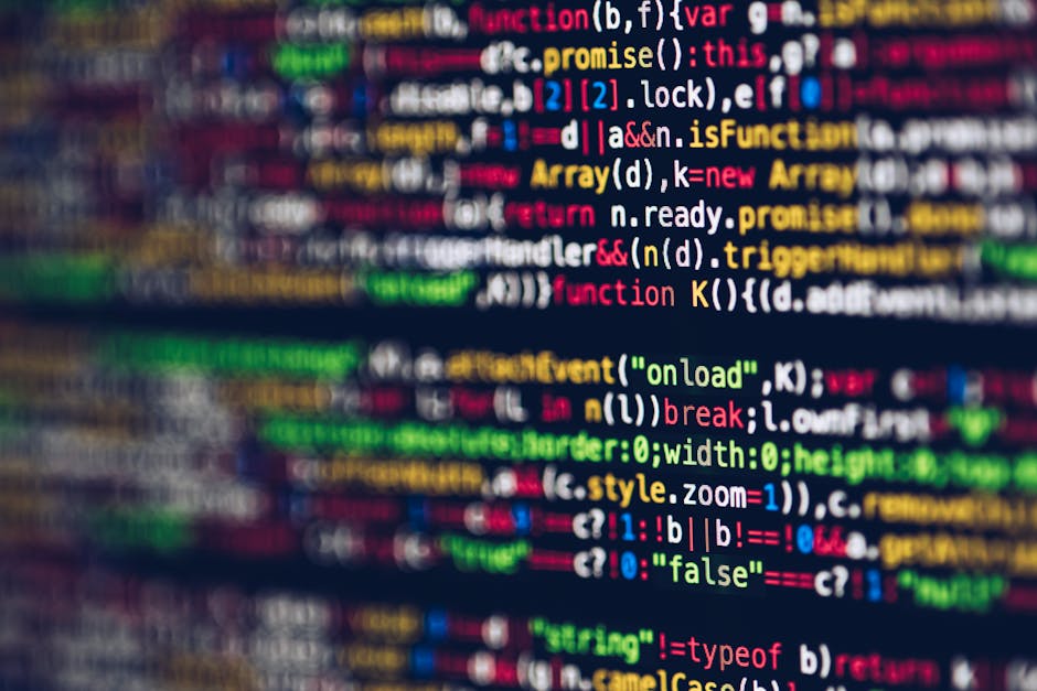 A close-up view of a computer screen displaying colorful lines of programming code in various coding languages, including JavaScript and HTML, with syntax highlighting in shades of red, green, yellow,