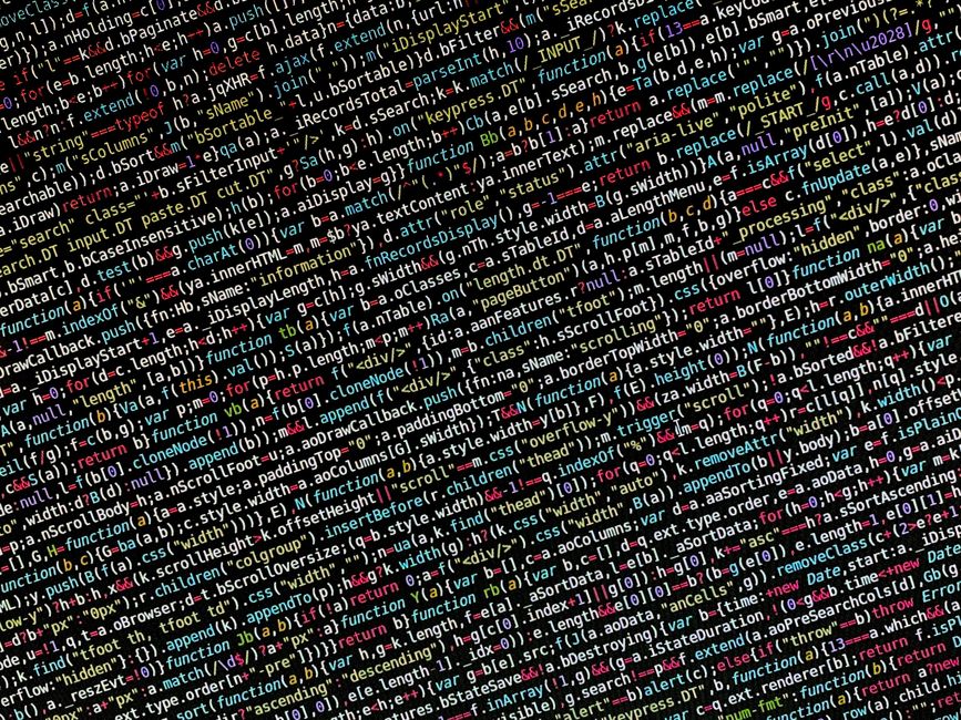 A close-up view of a computer screen displaying colorful lines of programming code in various coding languages, including JavaScript and HTML, with syntax highlighting in shades of red, green, yellow,